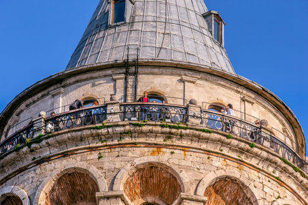 Unidentified people enjoy at top of Galata Tower, a medieval famous landmark stone tower...