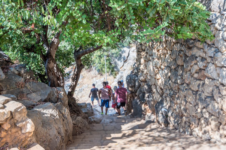 Unidentified people going down to stone slippery stairs towards cave of Chasm of Heaven in Silifke...