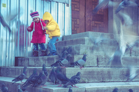 ISTANBUL/TURKEY- DECEMBER 24,2016: Unidentified children feed pigeons in The New Mosque (Yeni...