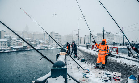 Unidentified people fishing on the galata bridge on a snowy day in winter.Istanbul,Turkey,07 January 2017のeditorial素材