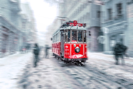 Motion Blurred:Winter view of nostalgic red Tram and people in daily life while snowing at popular Istiklal Street of Beyoglu,Istanbul,Turkey.07 January 2017のeditorial素材