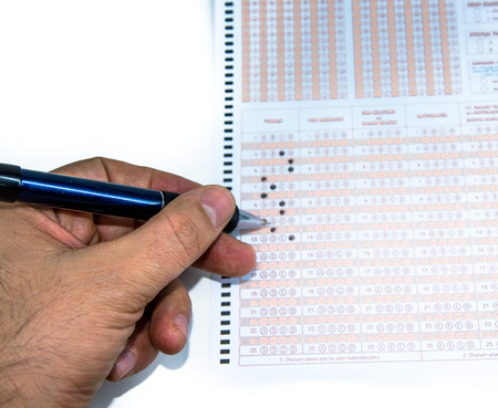Man hand marks ,fill out answer with pencil on Test score sheet with answers.の写真素材