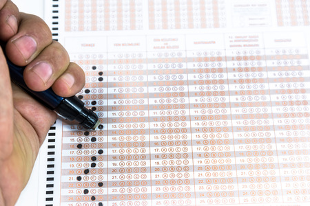 Man hand Erasing answer with pencil on Test score sheet with answers.の写真素材