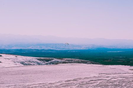 Turquoise color view of Pamukkale (Cotton Castle) is popular with Travertine pools and terraces  and a paraglide on the air.の写真素材