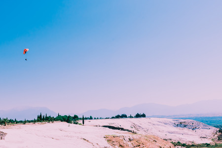 Turquoise color view of Pamukkale (Cotton Castle) is popular with Travertine pools and terraces  and a paraglide on the air.の写真素材