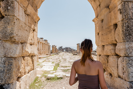 Woman stands near Byzantine Gate at Hierapolis ancient city in Pamukkale, Turkey.の写真素材