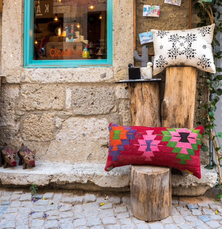 Colorful Decorations on a stone wall with blue window and different kind of ornaments on wooden log in Alacati,Turkey.のeditorial素材