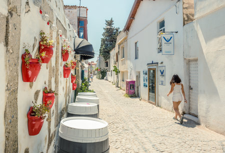 Unidentified People walk at a street with cafe and restaurant with tables and chairs  around at Alacati Town,a popular destination for traveling and vacation in Izmir,Turkey.26 August 2017.Retro Photo Filter Effectのeditorial素材
