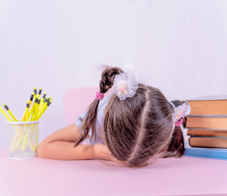 Cute little girl in school uniform sleeps on books.Selective focus and copy space for editing