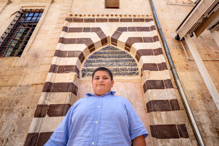Unidentified child poses at Gate of Ulu(Great) Mosque built between 1170-1175 in Sanliurfa,Turkey.19 July 2018のeditorial素材