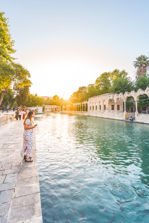 Unidentified woman watches fish in Halil-Ur Rahman Lake or named Balikli Gol(fish lake) in Sanliurfa,Turkey.18 July 2018のeditorial素材
