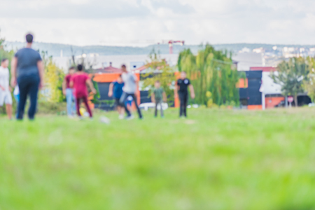 Blurred young children football players running and kicking soccer ball at park in day time.Copy space for editing.の写真素材