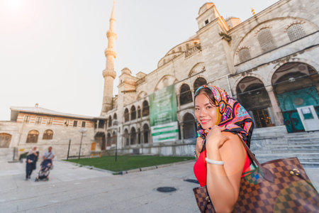 Beautiful woman poses with view of Sultanahmet or Blue Mosque on background in Istanbul,Turkeyの写真素材
