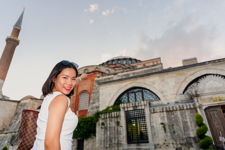Beautiful woman poses with view of Topkapi Palace on background in Istanbul,Turkeyの写真素材