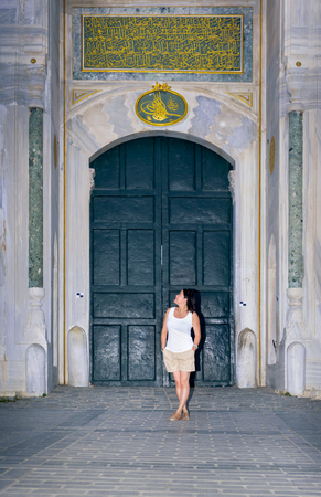 Beautiful woman poses with view of Topkapi Palace on background in Istanbul,Turkeyの写真素材