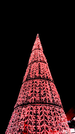 Figures of decorated Christmas tree with light bulbs with dark night backgroundの写真素材