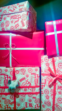 Front view of different size and color decorated gift boxes with ribbons and Christmas decorの写真素材
