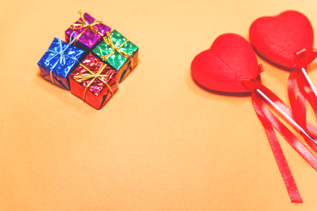 Top view of couple decorative red hearts shapes and small gift boxes on orange background.Holiday concept with isolated background.の写真素材