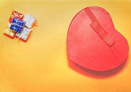 Top view of open red gift box with heart shaped and small gift boxes on orange background.Holiday concept with isolated background.の写真素材