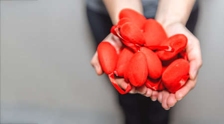 Female hands holds many small foam heart shapes.Valentines present. Heart in the hands.Valentines,love,family concept.Top view with copy spaceの写真素材