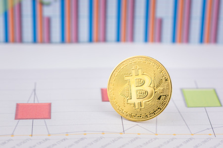 Golden Bitcoin, cryptocurrency physical coin with graph data chart . Virtual cryptocurrency concept.Concept image for cryptocurrencyの写真素材