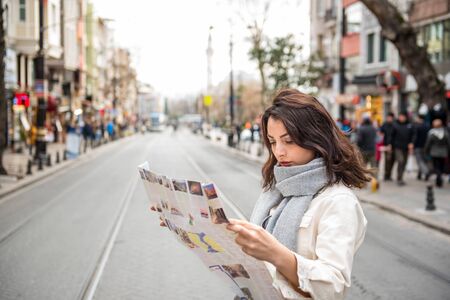 Beautiful young girl in fashionable clothes with map walks around and discover city in Istanbul,Turkey.Traveler woman  lifestyle Concept.の写真素材