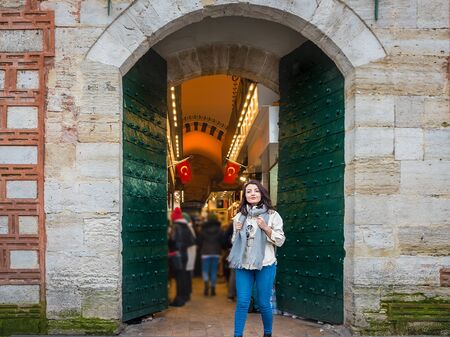 Attractive young beautiful girl poses at the gate of Egypt Bazaar in Eminonu,Istanbul,Turkeyの写真素材