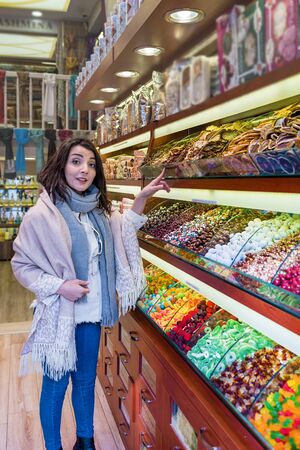 Beautiful traveler woman looks at traditional Turkish desserts sold a store in Istanbul,Turkey.Traveler woman  lifestyle Concept.の写真素材