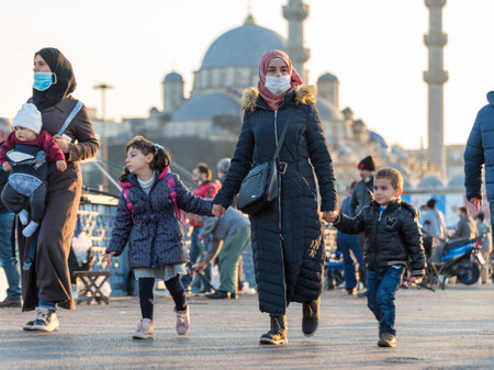 Unidentified Turkish people wearing protective face masks walking at Galata bridge during coronavirus COVID-19 epidemic.Istanbul,Turkey.16 November 2020のeditorial素材