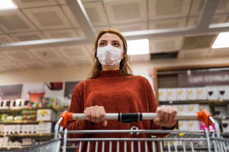 Beautiful woman wearing protective disposable mask shopping in mall. New normal concept during pandemic corona,covid19.の写真素材