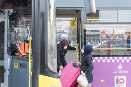 Unidentified Turkish people wearing protective face masks move to get out to buses during coronavirus COVID-19 epidemic.Istanbul,Turkey.16 November 2020のeditorial素材