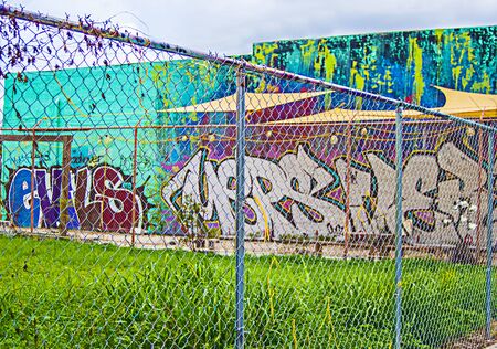 Miami Florida  - August 29, 2018 Wynwood District Miami Art Area Graffiti Wall Behind a Metal Fence of a main street.のeditorial素材