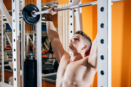 Handsome young man doing exercises in the gym. The concept of fitness, sports and a healthy...
