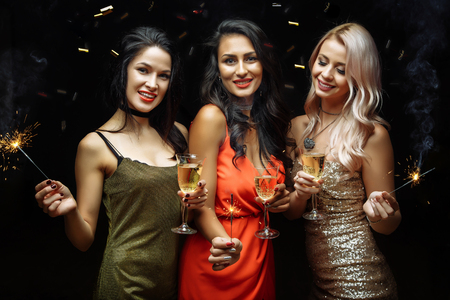 Celebration, friends, new year, christmas and winter holidays concept - happy women with glasses of champagne at bachelorette party at night clubの写真素材