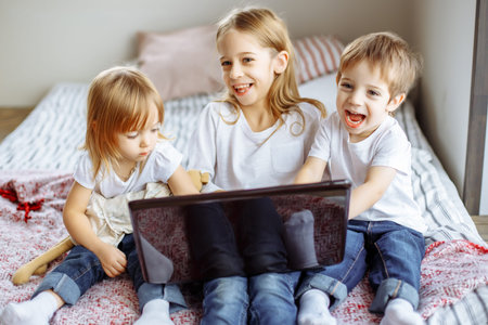 Kids playing with laptop computer at homeの写真素材