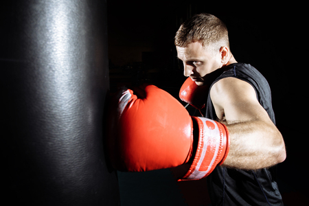 Boxer training on a punching bag in the gym.の写真素材