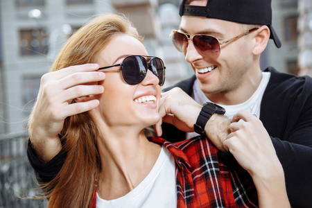 Young loving couple in sunglasses having fun togetherの写真素材