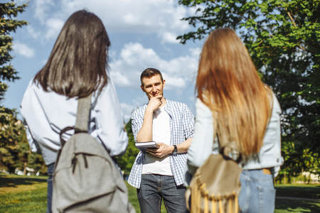 Young attractive guy making a choice between two girls. Love triangle.の写真素材