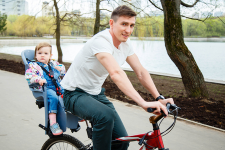 Young father and daughter riding a bicycle in the parkの写真素材