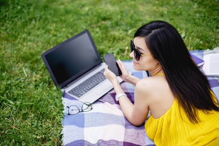 Young woman working on laptop in the outdoorの写真素材