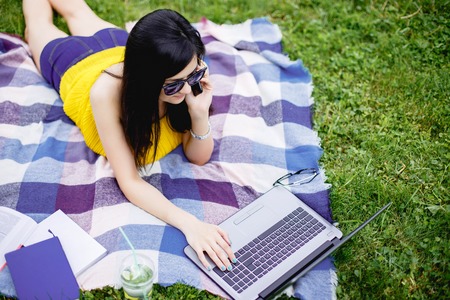 A young attractive woman studying outsideの写真素材