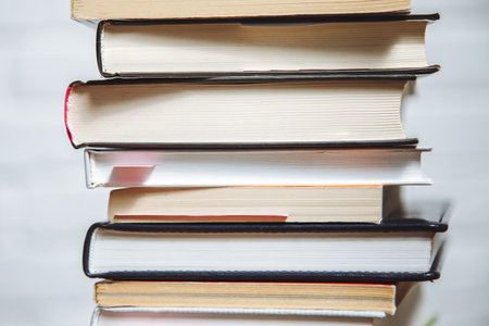 Stack of hardback books on wooden table. Back to school. Copy space for text
