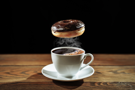 Donut and hot coffee on dark backgroundの写真素材