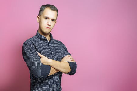 Handsome young man on a pink background.の写真素材