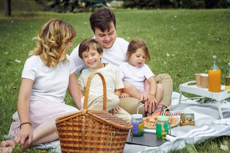 Happy family with kids resting on the grass during a picnic. Happiness and harmony in family lifeの写真素材