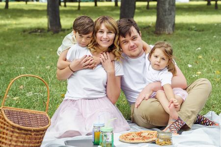 Portrait of a happy family on a picnic on a sunny summer day.の写真素材