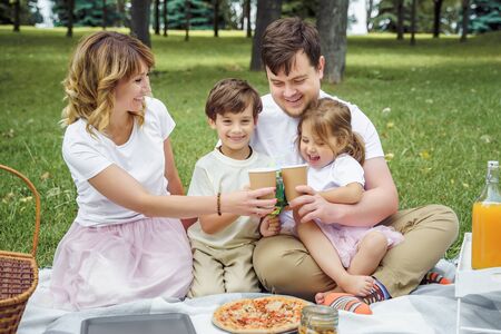 Happy family with kids resting on the grass during a picnic. Happiness and harmony in family lifeの写真素材