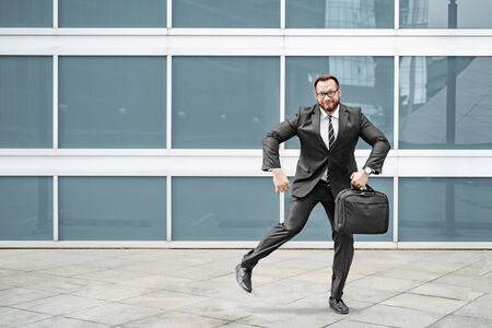 Ridiculous business man in a suit and glasses dancing in the streetの写真素材