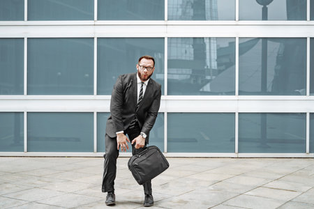 Cheerful business man fooling around near the office buildingの写真素材
