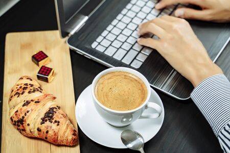 Croissant with chocolate and coffee on the desktop. Business breakfast conceptの写真素材